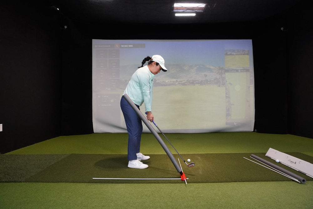 A golfer at address with the noodle set for swinging over it