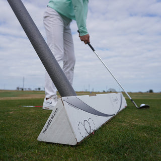 Golfer Practicing on range working on swing plane with alignment sticks