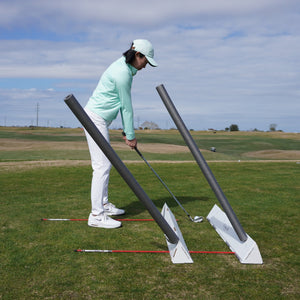 Golfer setup with an iron using two Golf Boks golf training aids, 2 alignment sticks, and 2 foam noodles to work on alignment, ball position. stance width, and club path