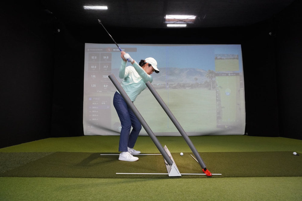 A golfer swinging between two noodles, one in the V6 and one held by the Golf Boks