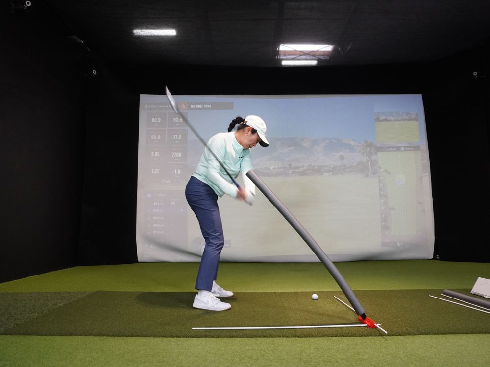 A golfer swinging under the foam noodle
