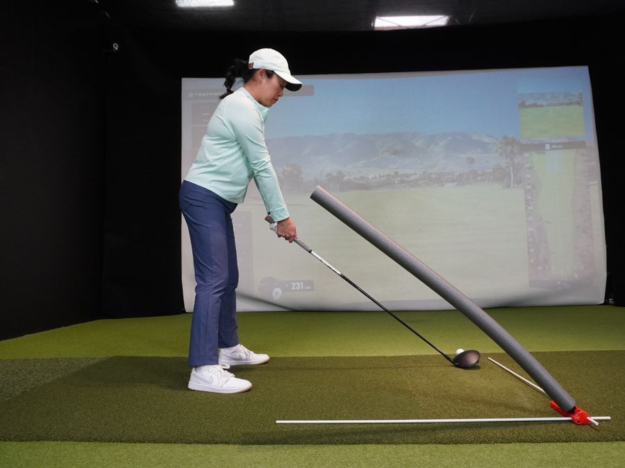 A golfer at address with a driver, the noodle set in the flattest slot of the V6