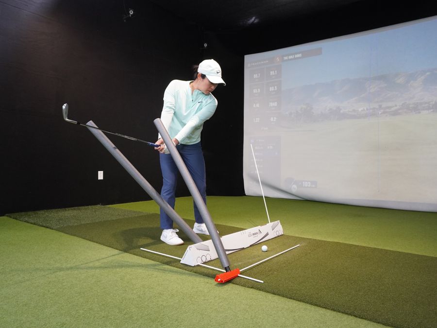 A golfer swinging along a plane board built from the Golf Boks and the V6